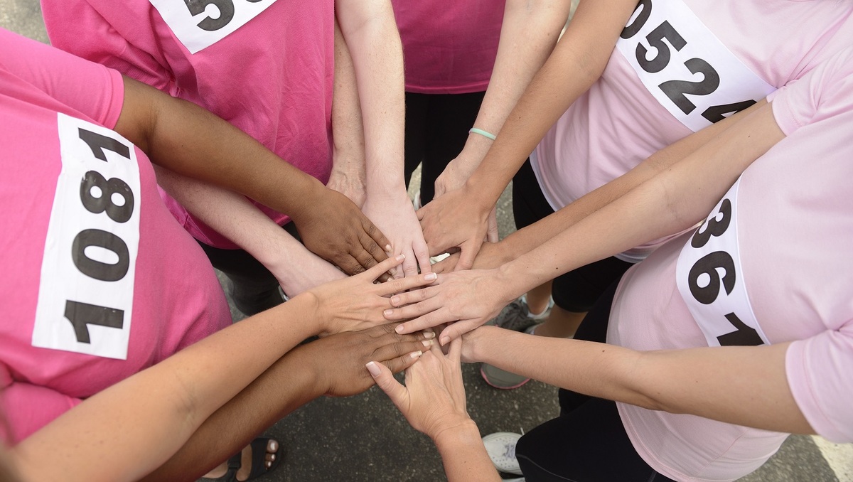 people putting hands in circle